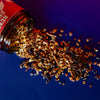Mulling Spices spilling out of a red and white container on a blue background