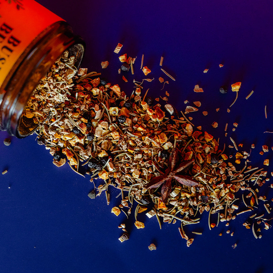 Spices spilling out of a labeled container on a blue background