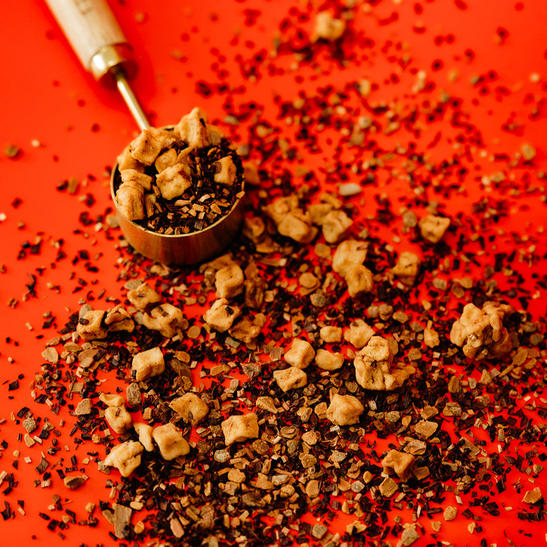 Wooden spoon with ground coffee on a red background