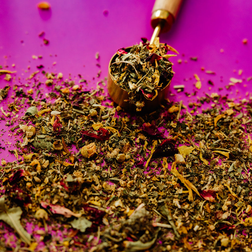 Tea leaves with a wooden scoop on a purple background